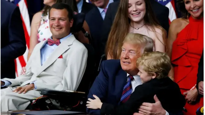 Seven-year-old Muscular Dystrophy patient Jordan McLinn, from Indiana, is embraced by U.S. President Donald Trump during the president"s signing of the "Right to Try Act,".