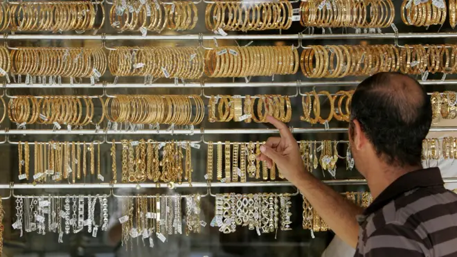رجل ينظر إلى أساور ذهب معروضة في محل في العاصمة الأردنية عمّان 