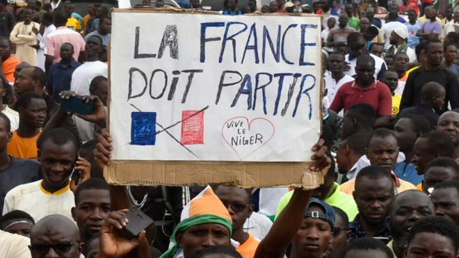 Man holding up a sign saying France must leave