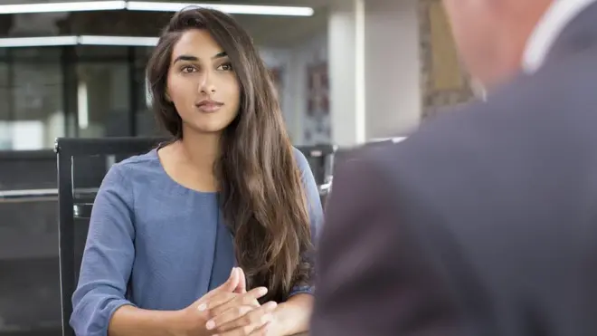 A woman sits opposite a man