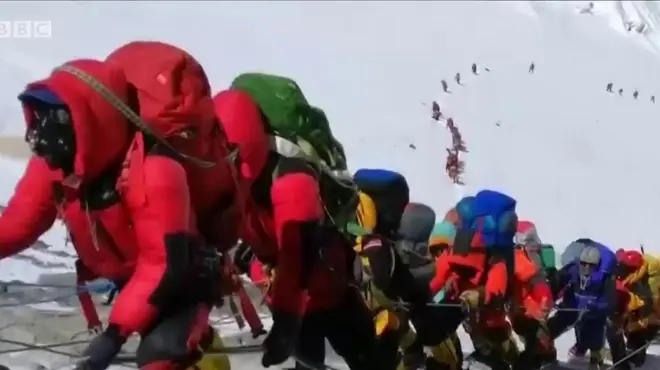 คนต่อแถวเดินบนเขา