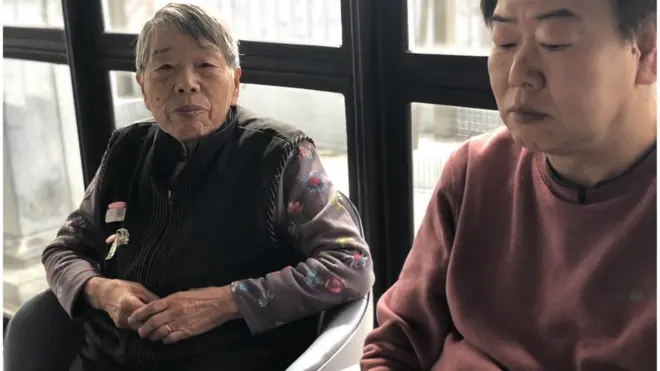 Bayan Itou, QR kodu olan iki kart takıyor