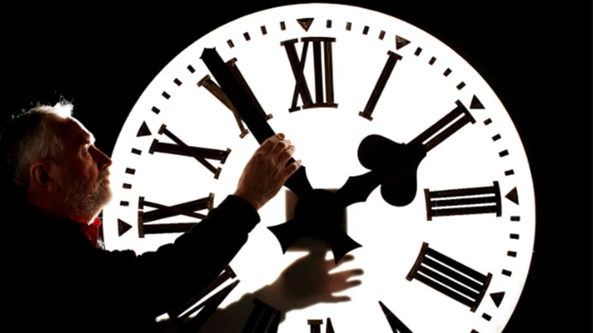 ภาพคนถือเข็มนาฬิกา