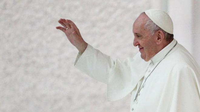 Aparecendo de perfil, Papa Francisco acena sorrindo