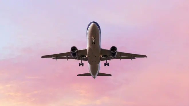 An aeroplane lands in a beautiful sunset