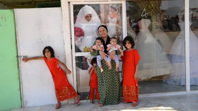 Розін з доньками біля дверей свого салону