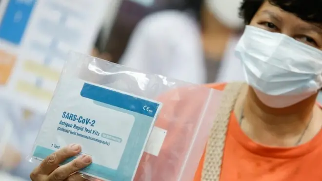 ประชาชนในพื้นที่เสี่ยงการระบาดของโควิด-19 ถือชุดตรวจ ATK ที่ได้รับแจกสำนักงานหลักประกันสุขภาพแห่งชาติเมื่อวันที่ 16 ก.ย.