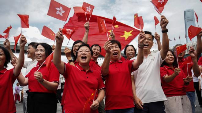 香港尖沙咀海旁亲北京政府红衣群众举起中国国旗与香港特区区旗欢呼（1/7/2023）