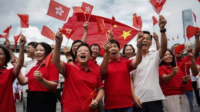 香港尖沙咀海旁亲北京政府红衣群众举起中国国旗与香港特区区旗欢呼（1/7/2023）