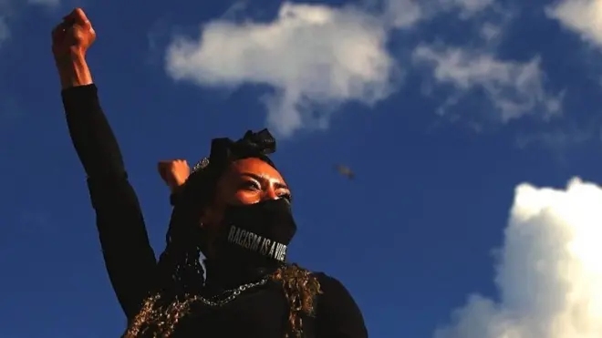 A demonstrator raises her fist during a Black Lives Matter protest in London, 20 June 2020