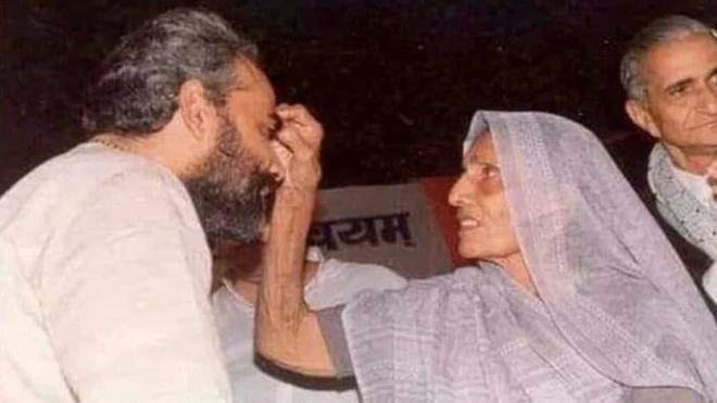 अहमदाबाद में हुए नागरिक सम्मान कार्यक्रम में मां हीराबेन मंच पर नरेंद्र मोदी का टीका करते हुए.