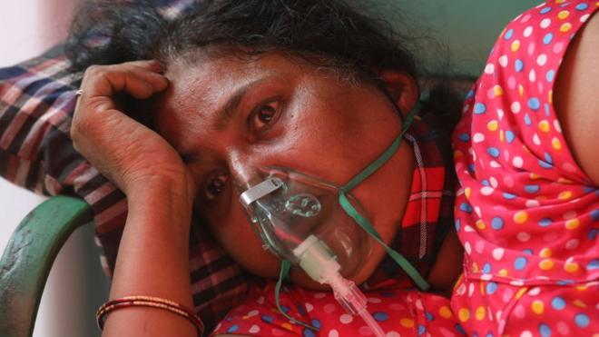 A woman breathing with the help of an oxygen cylinder in Delhi in April