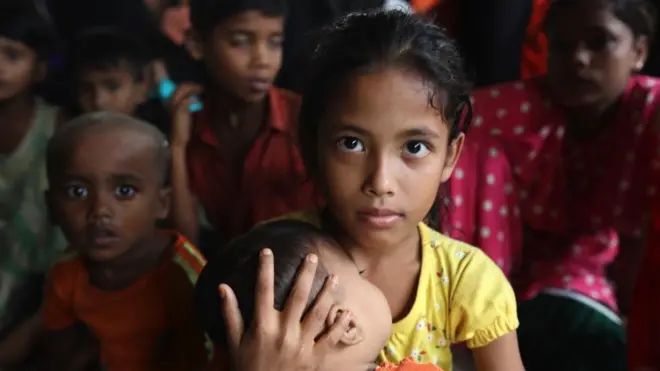 فتاة تحمل طفلاً رضيعاً في ملجأ من الإعصار في ميانمار