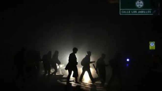 Gente caminando a su casa a oscuras.