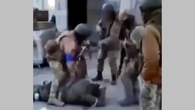 Still from the video showing soldier wearing a blue armbands