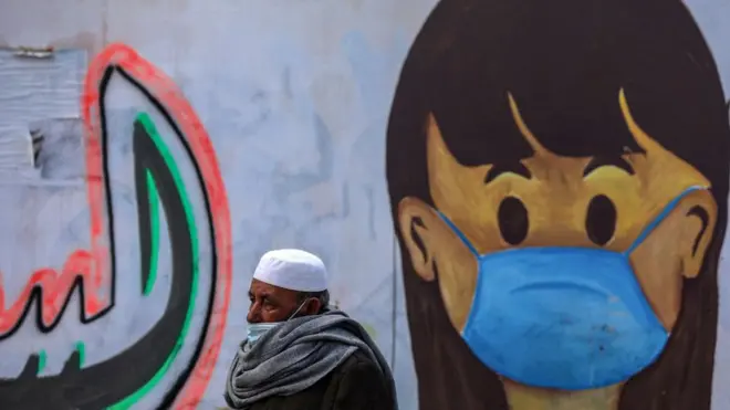 فلسطيني يسير بجوار جدارية في قطاع غزة.