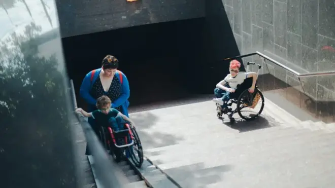 Москвичка с сыновьями пытается подняться по пандусу в подземном переходе