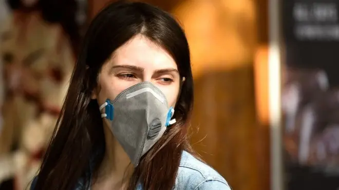 માસ્ક પહેરેલાં યુવતી