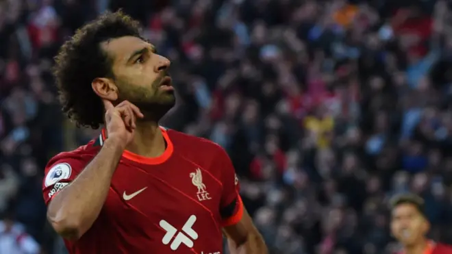 Mohamed Salah holds his finger to his ear as if to ask for more noise from the crowd