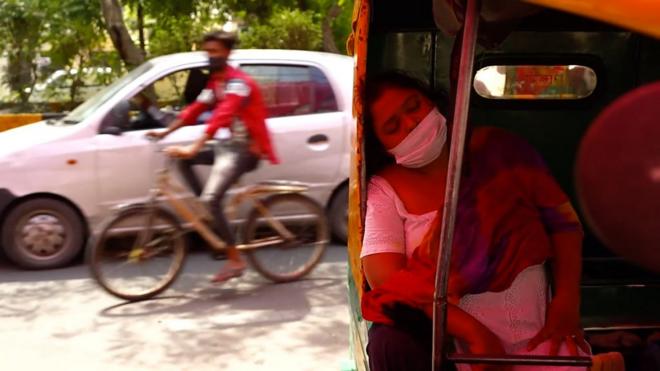 印度德里街頭一名在摩托三輪車上歇息的女士