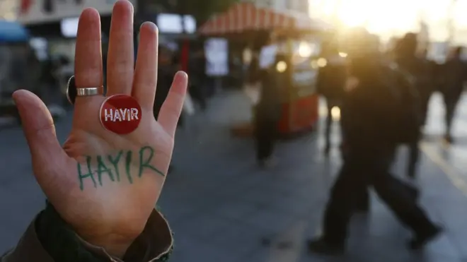 امراة تركية ترفع كفها وقد كتبت عليه كلمة "لا" للتعديلات الدستورية