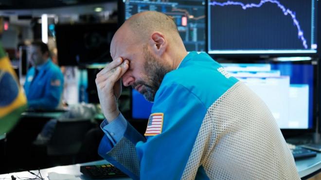 Funcionário de bolsa americana lamentando cenário de queda de ações