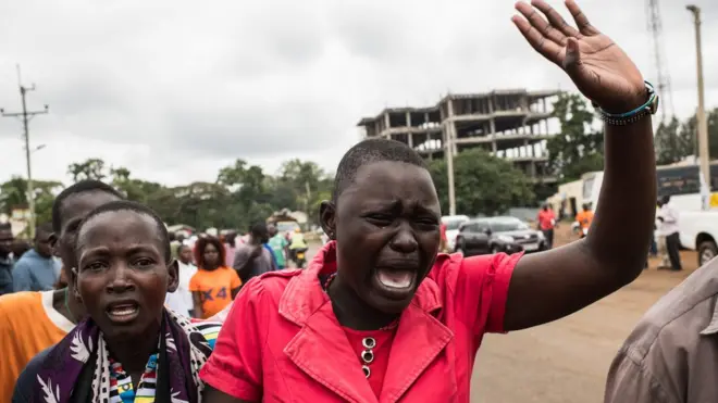 Judith Omondi dey dry as dem dey bury her husband Stephen; im be one of three men wey die after police and protesters clash, on 20 October for Bondo, Kenya.