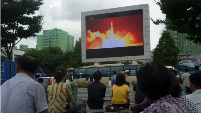 Pyongyang'da halk bir füze denemesinin görüntülerini izlerken.