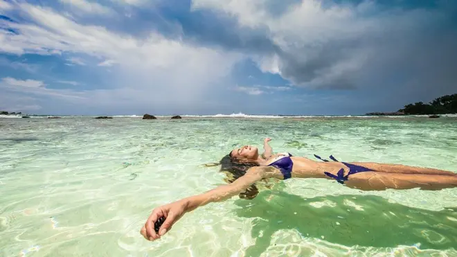 Chica flotando en aguas cristalinas
