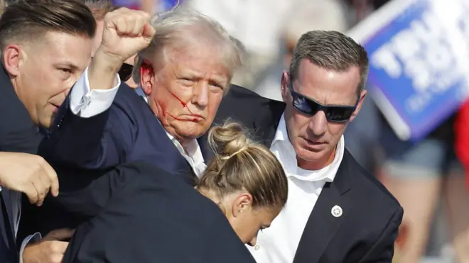 特朗普在賓夕法尼亞州巴特勒遭槍擊後朝著支持者舉起拳頭（13/7/2024）