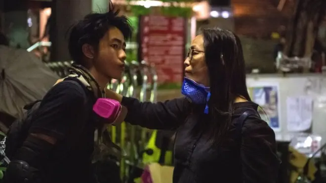 Seorang dosen PolyU berbicara kepada seorang mahasiswa setelah aparat mengumumkan bahwa demonstran berusia di bawah 18 tahun bisa meninggalkan kampus.