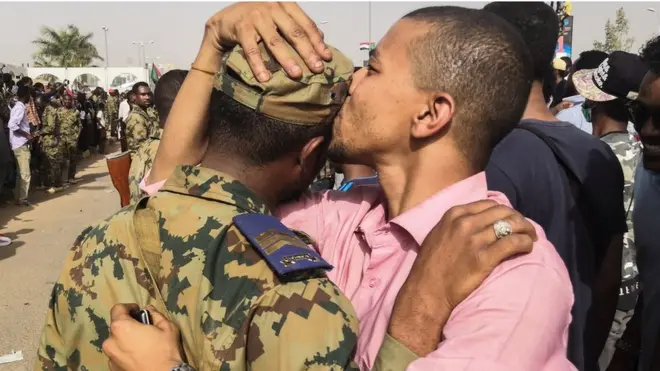 Muandamanaji wa Sudan akimbusu mwanajeshi siku ya Alhamisi kabla ya kutangazwa kwamba rais Omar al-Bashir amepinduliwa