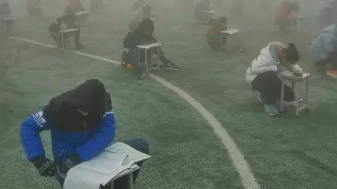 Walau sedang dilanda kabut polusi, para murid di Hebei mengerjakan ujian di tempat terbuka.