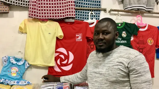 Muhammad Bathily bersama contoh barang-barang yang dia jual.