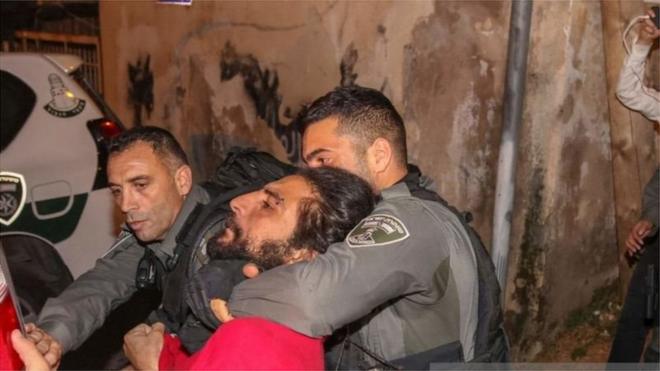 شاب في قبضة عناصر ترتدي زي الشرطة الإسرائيلية