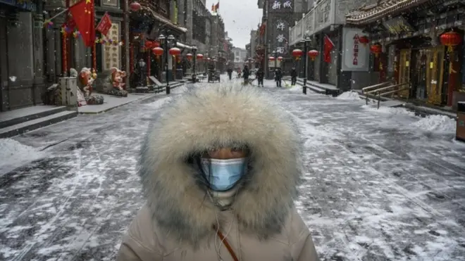 ภาพหญิงชาวจีนเดินอยู่บนถนนสายการค้าอันว่างเปล่าในช่วงที่เชื้อไวรัสโคโรนาสายพันธุ์ใหม่ระบาดไปทั่วประเทศจีน