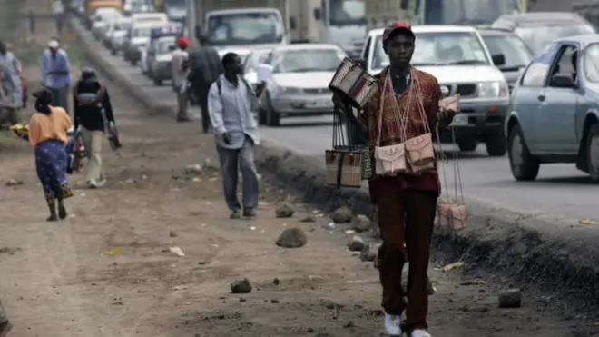 une jeune vendeur ambulant dans les rues de Nairobi tentant de gagner sa vie .