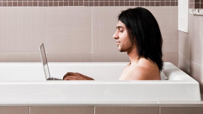 Man in bath with laptop