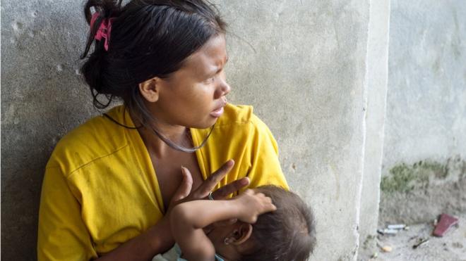 Mujer latinoamericana amamantando a su bebé.