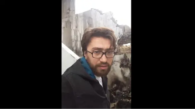 Yerli fəal və jurnalist Salah Ashkar şərqi Hələbdə qaldığı binaya dəyən zərbənin yerini göstərir.