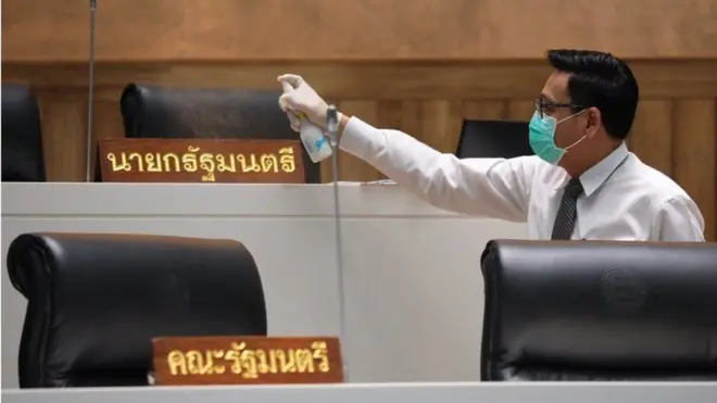เจ้าหน้าที่ฉีดพ่นทำความสะอาดที่นั่งนายกฯ และ ครม. ภายในห้องประชุมรัฐสภา เพื่อป้องกันเชื้อโควิด-19