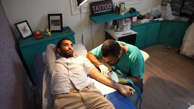 Un homme en train de se faire tatouer en Tunisie