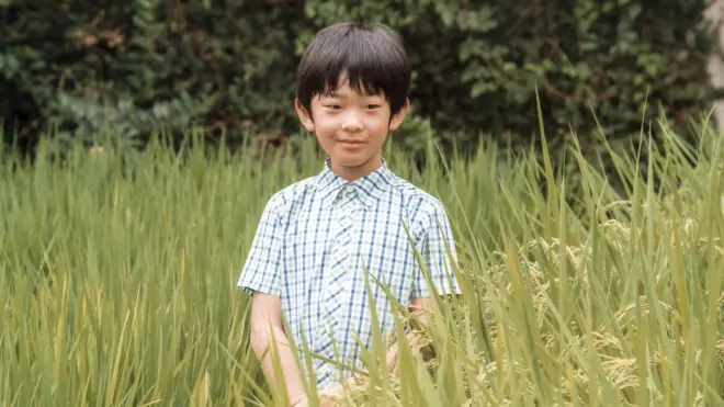 Prince Hisahito is seen posing in a rice field at the Akishino-no-miya residence in Tokyo