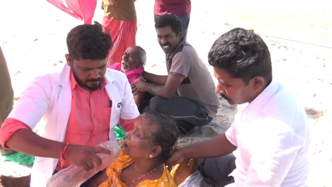 දනුෂ්කොඩි වෙරළේ සිහිසුන්ව වැටී සිටින පරමේෂ්වරීට ජුනි 27 දා) රාමේශ්වරන් වෙරළාරක්ෂක බලකාය විසින් සත්කාර කරන අයුරු