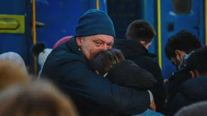 A man says goodbye to his daughter before she boards an evacuation train at Kyiv's central railway station on 28 February 2022
