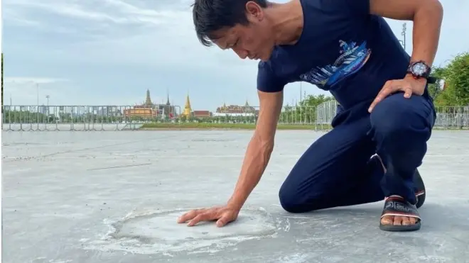 ชายคนหนึ่งสำรวจพื้นปูนบริเวณที่หมุดคณะราษฎร 2563 เคยฝังอยู่