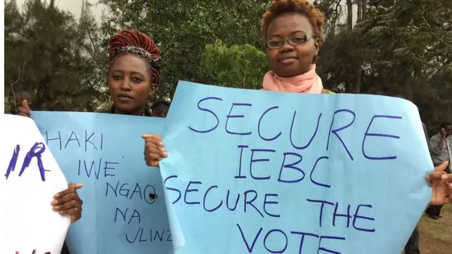 Waandamanaji wamebeba mabango kuunga mkono tume ya uchaguzi