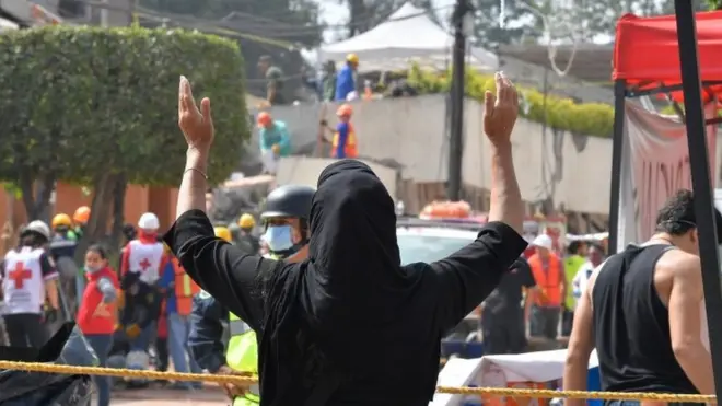 Woman reacts outside school hit by quake