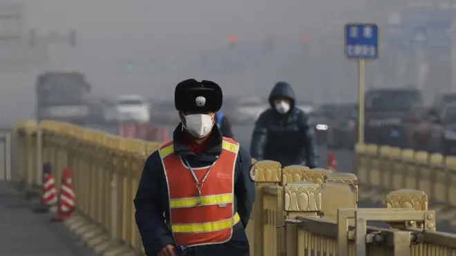 Polisi lalu lintas mengenakan masker ketika berpatroli di Beijing di tengah kabut asap yang menyelimuti ibu kota Cina.