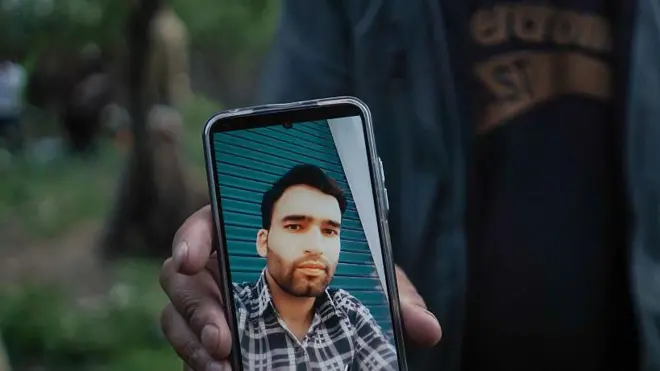 सैयद आदिल हुसैन शाह की तस्वीर दिखाते रिश्तेदार